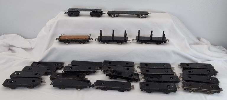 Twenty-five Marx O Gauge flat cars, pipe/log cars, chassis olive drab