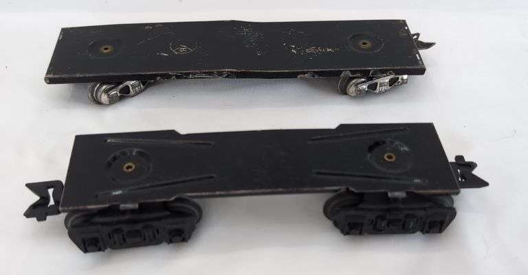 Twenty-five Marx O Gauge flat cars, pipe/log cars, chassis olive drab