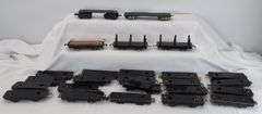 Twenty-five Marx O Gauge flat cars, pipe/log cars, chassis olive drab