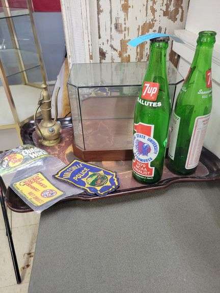 Collection of Memorabilia: 7-Up Bottles, Police Patch, Brass Water Pitcher, and Bond 007 Display image